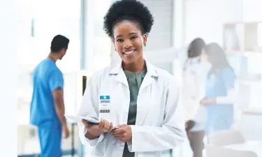 Minnesota DNP nurse executive smiling with patient charts in hospital